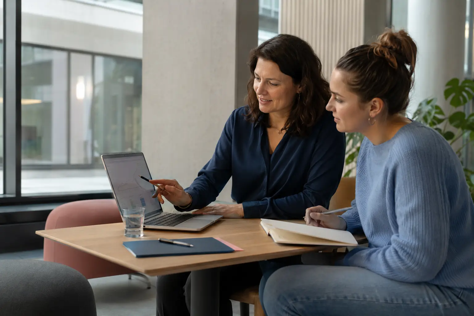 Docent en hbo-student bespreken samen leerresultaten op een laptop.